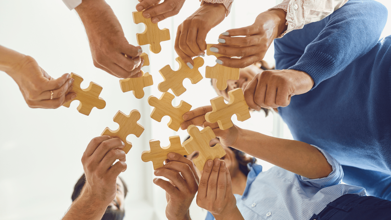 Team collaboration – Hands putting puzzle pieces together, symbolizing unity, expertise, and shared values among dietitians