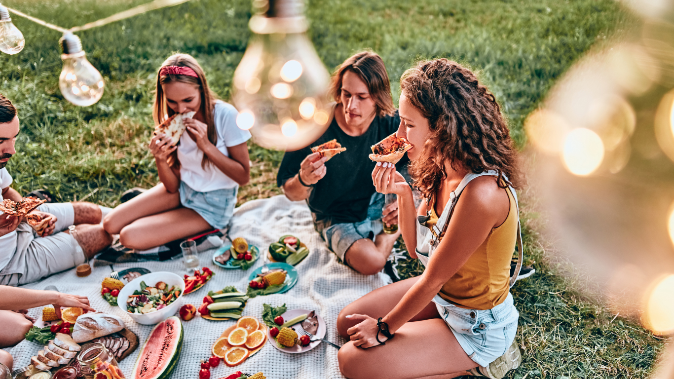 A group of friends enjoying a picnic together, sharing food and laughter in a peaceful outdoor setting.