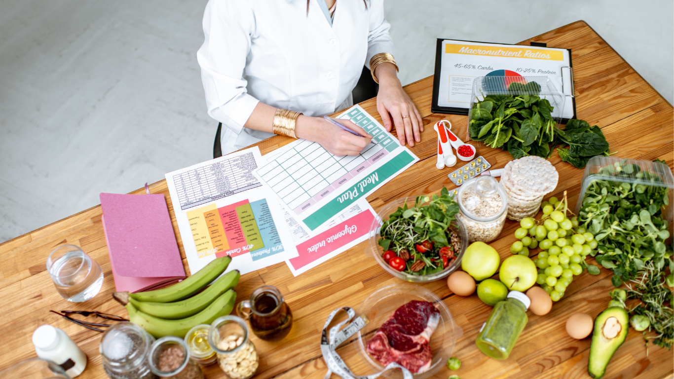 Close-up of hands writing in a food diary and meal plan, focusing on guided nutrition for kidney health