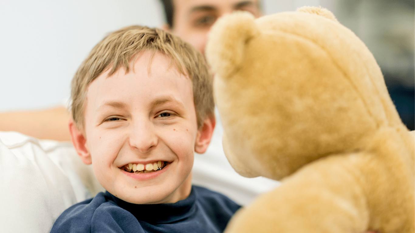 A heartwarming scene of a child with a developmental disability holding a teddy bear during a friendly nutrition consultation at My Nutrition Clinic