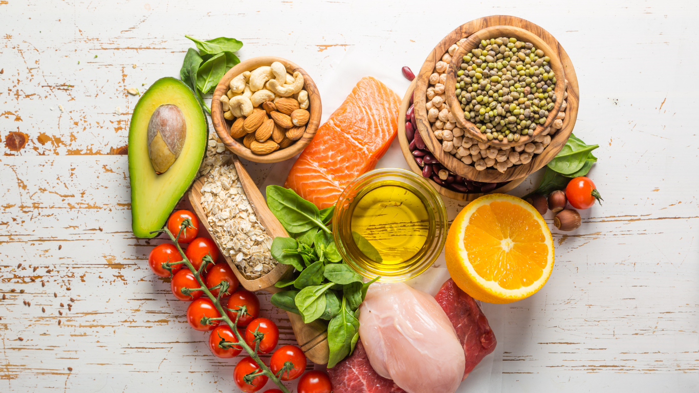 Heart-shaped arrangement of heart-healthy foods including nuts, olive oil, avocado, and whole grains recommended by Gold Coast dietitians